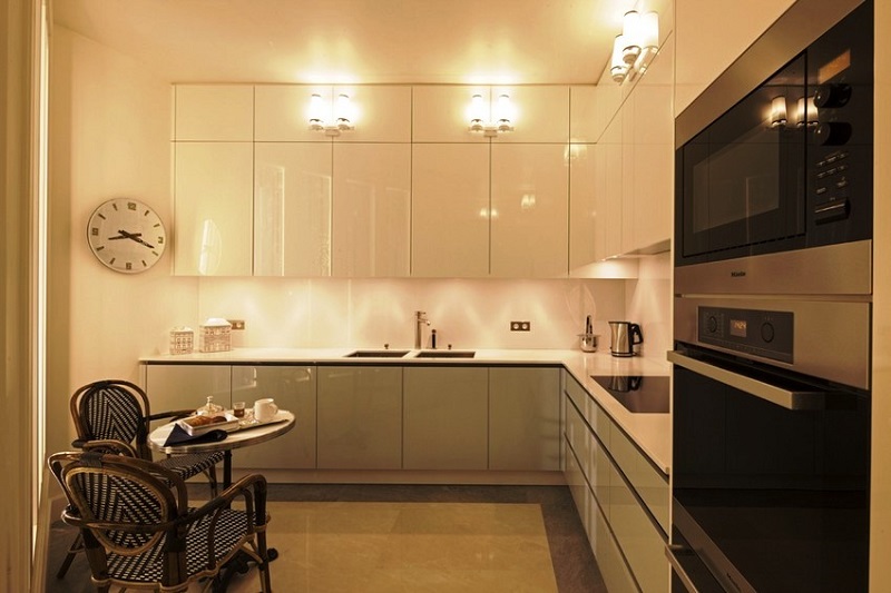 Белая глянцевая кухня под потолок с высокими верхними антресолями с глянцевой поверхностью