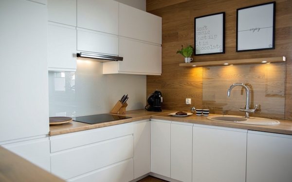 Белая угловая кухня с деревянной столешницей с горизонтальными верхними шкафами