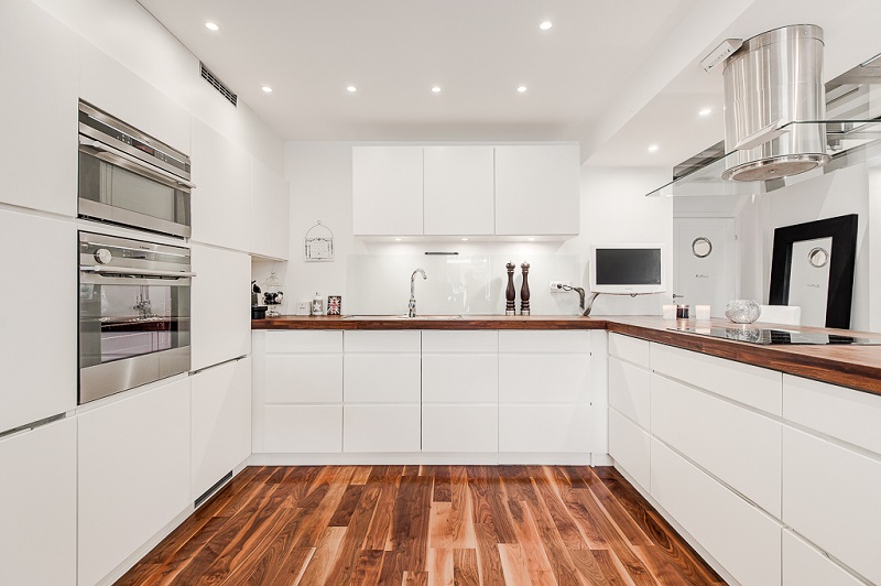 Белая кухня минимализм П-образной формы с деревянной столешницей
