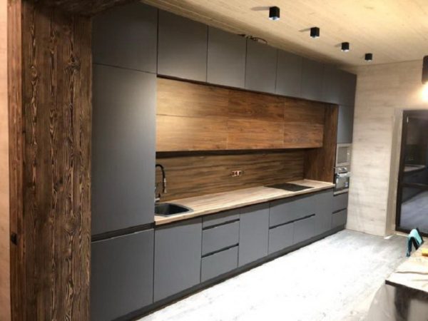 Серая стильная кухня с деревянной столешницей под потолок со встроенным холодильником