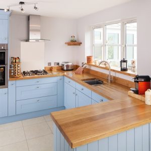 Голубая кухня с деревянной столешницей П-образной формы