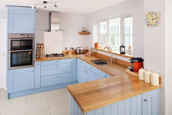 Голубая кухня с деревянной столешницей П-образной формы