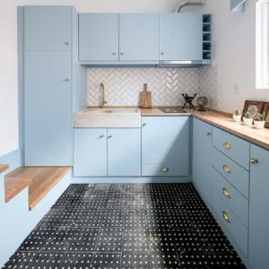 Голубая кухня с деревянной столешницей угловой формы со встроенным холодильником